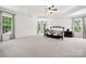 Serene main bedroom featuring tray ceilings, neutral carpet, and large windows with views of nature at 109 Braxton Gate Ct, Mount Holly, NC 28120