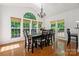 Elegant dining room featuring hardwood floors, chandelier, and abundant natural light through large windows at 109 Braxton Gate Ct, Mount Holly, NC 28120