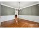 Traditional dining room with hardwood floors, a decorative chandelier, and classic wainscoting at 109 Braxton Gate Ct, Mount Holly, NC 28120