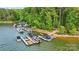 Picturesque view of several boat docks along a tranquil lake shore with lush greenery in the background at 109 Braxton Gate Ct, Mount Holly, NC 28120