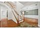 Inviting entryway with hardwood floors, a staircase with white railings and an adjacent dining room with chandelier at 109 Braxton Gate Ct, Mount Holly, NC 28120