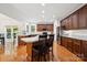 Modern kitchen with a large island, dark wood cabinets, stainless steel appliances, and hardwood floors at 109 Braxton Gate Ct, Mount Holly, NC 28120