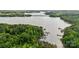 Picturesque aerial view of a lake with docks and boats, surrounded by lush green trees and a clear blue sky at 109 Braxton Gate Ct, Mount Holly, NC 28120