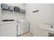 Practical laundry room equipped with washer, dryer, utility sink, and shelving at 109 Braxton Gate Ct, Mount Holly, NC 28120
