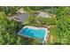 Aerial view of a community swimming pool with lounge chairs, surrounded by lush trees and a parking lot nearby at 109 Braxton Gate Ct, Mount Holly, NC 28120