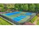 Aerial view of outdoor tennis and pickleball courts surrounded by greenery and a tall fence at 109 Braxton Gate Ct, Mount Holly, NC 28120