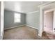 A gray, carpeted bedroom featuring a bright window and neutral walls provides a cozy, adaptable space at 1105 S Church S St, Monroe, NC 28112
