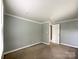 A gray, carpeted bedroom featuring crisp white trim and neutral walls provides a cozy, adaptable space at 1105 S Church S St, Monroe, NC 28112