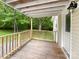 View of the well-maintained covered deck featuring wooden railings and ample natural light at 1105 S Church S St, Monroe, NC 28112