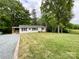 View of the home with its well-kept lawn and outdoor covered deck at 1105 S Church S St, Monroe, NC 28112