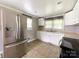 Bright kitchen with white cabinets, stainless steel refrigerator, and checkered valances for a charming feel at 1105 S Church S St, Monroe, NC 28112