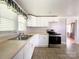 Well-lit kitchen featuring white cabinetry, stainless steel appliances, and a classic, functional layout at 1105 S Church S St, Monroe, NC 28112
