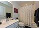 Well-lit bathroom showcasing a white vanity, a framed mirror, and a shower with a polka-dot curtain at 11741 Blessington Rd, Huntersville, NC 28078