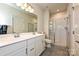 Modern bathroom featuring double sinks, a tiled shower with glass doors, and a separate toilet area at 11741 Blessington Rd, Huntersville, NC 28078