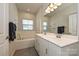 Bright bathroom with a double sink vanity, a soaking tub, and a large window for natural light at 11741 Blessington Rd, Huntersville, NC 28078