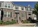Charming townhome showcasing a stone facade, sage shutters, and a neatly landscaped front entrance at 11741 Blessington Rd, Huntersville, NC 28078