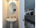 Stylish powder room features a pedestal sink and oval mirror, conveniently located near the main living area at 11741 Blessington Rd, Huntersville, NC 28078