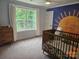 Light-filled Bedroom with a crib, dresser, and a whimsical sun mural on the accent wall at 1200 Kent Dr, Lancaster, SC 29720