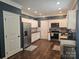 This kitchen features white cabinets, stainless steel appliances, hard wood flooring, and a stylish backsplash at 1200 Kent Dr, Lancaster, SC 29720