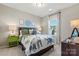 Comfortable bedroom with large window, side tables with lamps and dinosaur themed decor and bedding at 13251 Chopin Ridge Rd, Huntersville, NC 28078