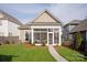 Back exterior of home with sunroom addition, green grass and landscaping at 13818 Jacks Ln, Pineville, NC 28134