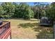 Expansive fenced backyard featuring a trampoline, playhouse, and ample space for outdoor activities at 140 Ribbon Cir, Lincolnton, NC 28092