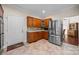 Kitchen with stainless steel refrigerator, tile floors, wooden cabinets, and granite countertops at 140 Ribbon Cir, Lincolnton, NC 28092