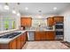 Bright kitchen boasts wooden cabinets, tile floors, stainless appliances, and granite countertops at 140 Ribbon Cir, Lincolnton, NC 28092
