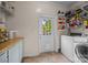 Laundry room featuring modern washer and dryer, shelving, and rear yard access at 140 Ribbon Cir, Lincolnton, NC 28092
