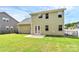 Expansive backyard featuring lush green grass and a patio, enclosed by a black fence. The house has sage siding at 16019 Kelby Cv, Charlotte, NC 28278