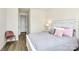 This is a bedroom with wood-look floors and is decorated with a chair and nightstand. A door is open into a hall at 16019 Kelby Cv, Charlotte, NC 28278