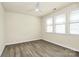 Sunlit bedroom with hardwood floors, a ceiling fan, and large windows offering ample natural light at 16019 Kelby Cv, Charlotte, NC 28278
