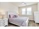 Cozy bedroom with a large bed, nightstands, and natural light from a window. It features a ceiling fan and wood-look floors at 16019 Kelby Cv, Charlotte, NC 28278