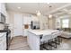 Stylish kitchen boasts white cabinets, stainless steel appliances, island, and breakfast bar at 16019 Kelby Cv, Charlotte, NC 28278
