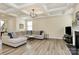 Bright living room boasts tray ceilings, hardwood floors, fireplace, and neutral decor at 16019 Kelby Cv, Charlotte, NC 28278