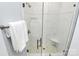 Updated glass shower showcasing white tile surround, bronze fixtures, and integrated shelving at 16019 Kelby Cv, Charlotte, NC 28278