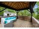 Gazebo with ample blue seating and a mounted TV overlooking the spacious back yard at 17403 Green Hill Rd, Charlotte, NC 28278