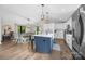 Open kitchen with white cabinets, an island, and a dining area with modern lighting and hardwood flooring at 17403 Green Hill Rd, Charlotte, NC 28278