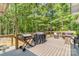 A backyard deck with a grill and sitting area is surrounded by a lush green forest at 1800 Oriole Ct, Monroe, NC 28112