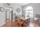 Sunlit dining area features wood floors, neutral paint, and an eye-catching wooden table with accent pillows on seats at 1800 Oriole Ct, Monroe, NC 28112