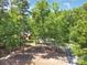 Home exterior surrounded by lush trees, showcasing a private setting with a long drive at 1800 Oriole Ct, Monroe, NC 28112