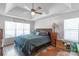 Cozy main bedroom features a tray ceiling, fan, natural light, and hardwood floors at 1800 Oriole Ct, Monroe, NC 28112
