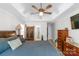 Well-appointed bedroom featuring a tray ceiling, ceiling fan, plush bedding, and hardwood floors at 1800 Oriole Ct, Monroe, NC 28112