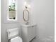 Neat powder room with a stylish oval mirror and a marble countertop vanity at 1829 Union St, Charlotte, NC 28205