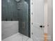 Modern bathroom shower with marble and green tile, glass door, brass fixtures, and white door entrance at 1829 Union St, Charlotte, NC 28205