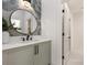 Modern bathroom with a round mirror, decorative wall tiles, and a white countertop at 1829 Union St, Charlotte, NC 28205