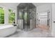 Bathroom featuring a glass-enclosed shower, soaking tub, and walk-in closet at 1829 Union St, Charlotte, NC 28205