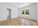Well-lit bedroom with hardwood floors and a door leading to a brightly-lit bathroom at 1829 Union St, Charlotte, NC 28205