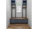 Custom blue mudroom with shelving, storage bench, wooden accents, and built-in lighting near window at 1829 Union St, Charlotte, NC 28205