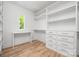 Walk-in closet featuring hardwood floors, built in shelves, and desk area at 1829 Union St, Charlotte, NC 28205